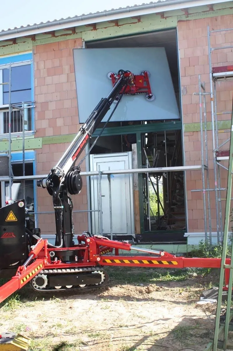 glasboy510 hebt ein großes Stück Glas in ein Gebäude.
